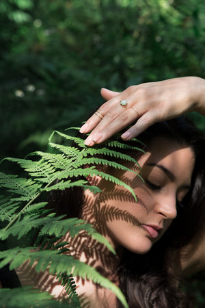Woman touching fern wearing Opal Hexagon Ring, Horizon Ring and Wrap Midi Ring  by Rockhaus Metals